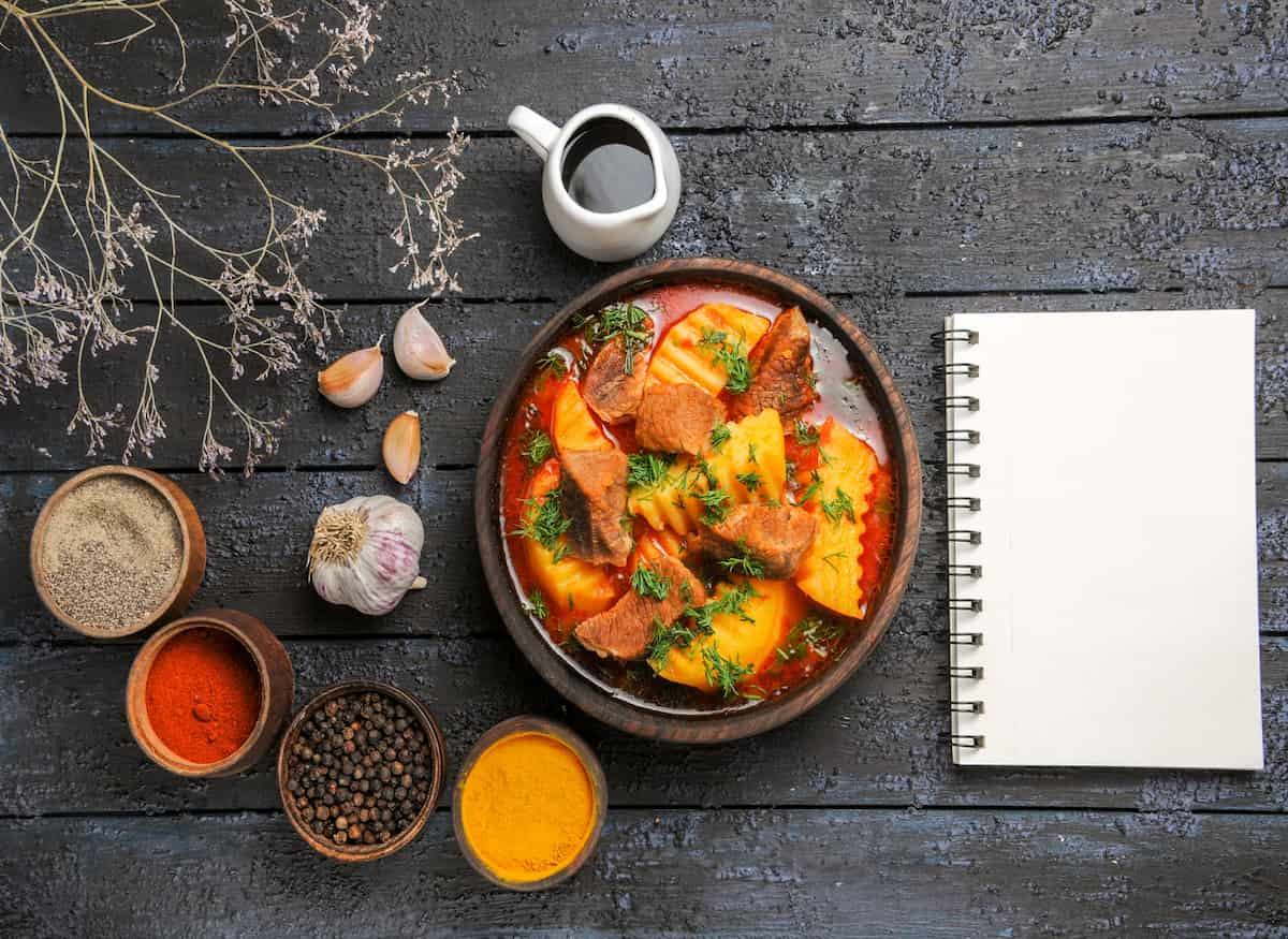 Leftovers Indian cuisine featuring spices and dishes on a rustic wooden table